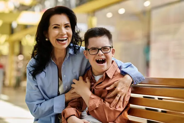 A mother and her son with Down syndrome share a laugh and enjoy a day together at a shopping mall. — Stock Photo