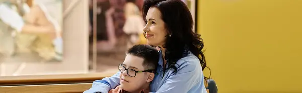 A mother and her son with Down syndrome walk through a shopping mall, sharing a moment of togetherness. — Stock Photo