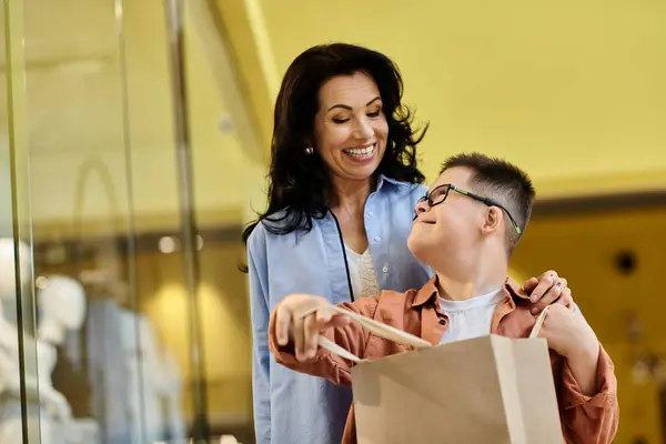 A mother and her son with Down syndrome enjoy a shopping trip at a mall, sharing a happy moment. — Stock Photo