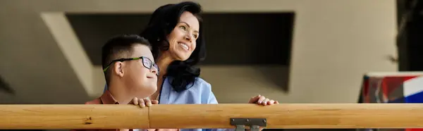 A mother and her son with Down syndrome smile brightly as they walk through a shopping mall, enjoying their time together. — Stock Photo