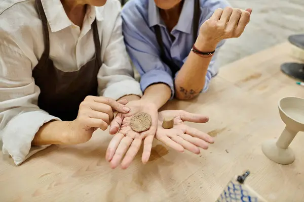 A mature lesbian couple working together in a pottery studio. — Stock Photo