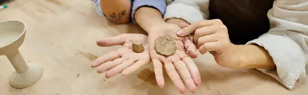 A close-up of a mature lesbian couples hands shaping clay during a pottery session. — Stock Photo