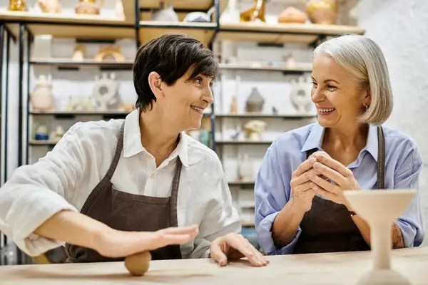 A lesbian couple crafts pottery together in a cozy studio. — Stock Photo