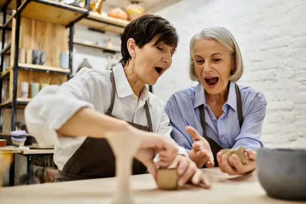 Two mature women working on pottery in an art studio. — Stock Photo
