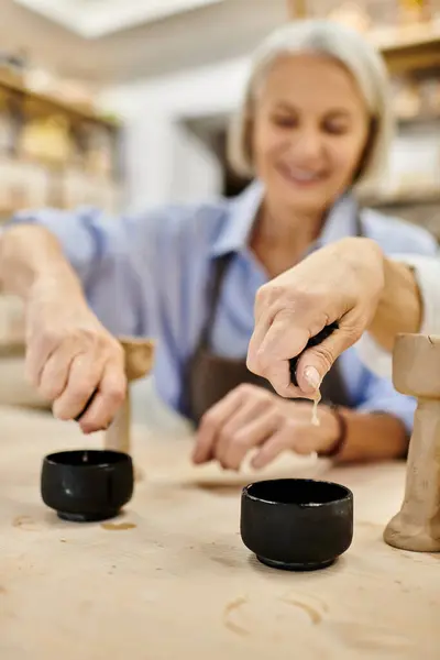 A mature lesbian couple crafts pottery together in a cozy studio. — Stock Photo