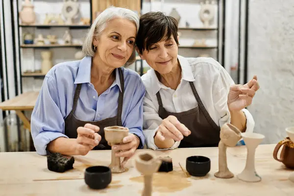 Duas mulheres, vestidas com roupas aconchegantes, trabalham em projetos de cerâmica em um estúdio de arte. — Fotografia de Stock