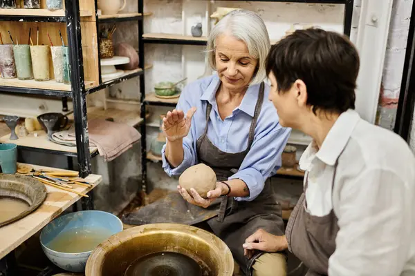 Two women, a mature lesbian couple, work on pottery in a cozy studio. — Stock Photo