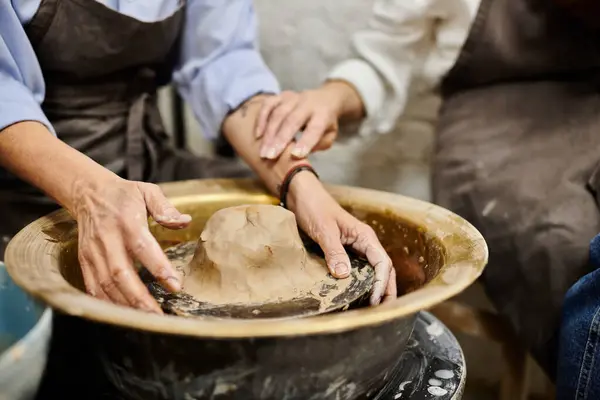 A lesbian couple creates a piece of pottery together in an art studio. — Stock Photo