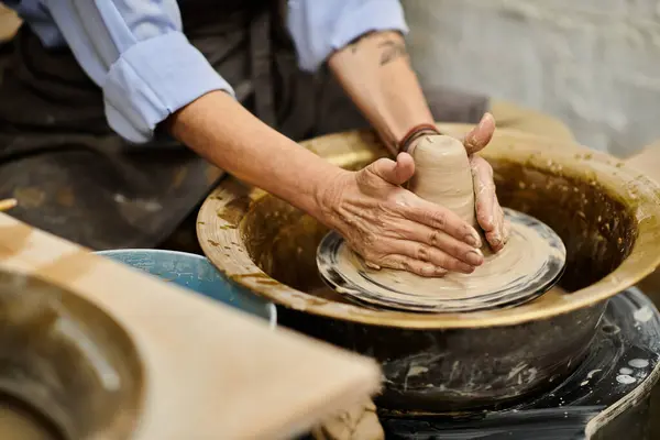 A close-up of a womans hands shaping clay on a pottery wheel. — Stock Photo