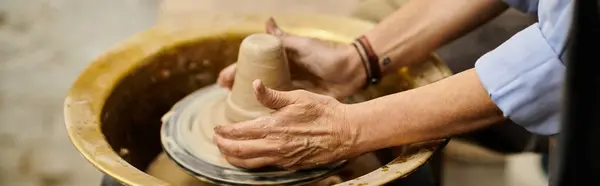 A womans hands shape clay on a pottery wheel. — Stock Photo