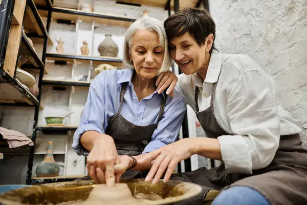 Two mature women craft pottery in a cozy studio setting. — Stock Photo