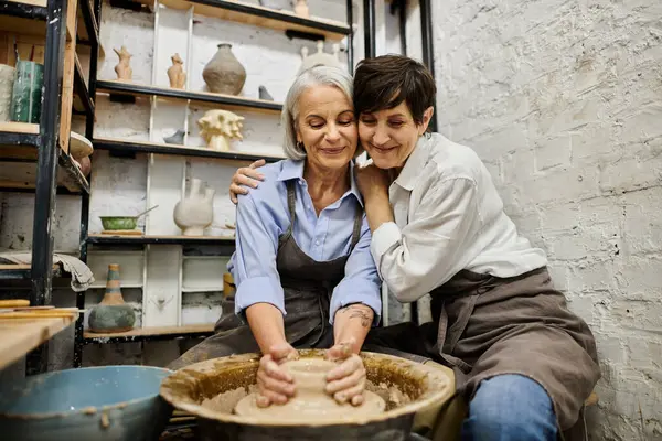 Two mature women, a lesbian couple, are working on pottery in a cozy art studio. — Stock Photo