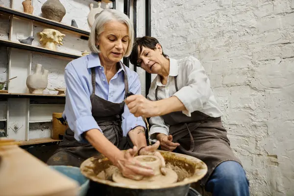 A lesbian couple works together on a pottery project in a cozy studio. — Stock Photo