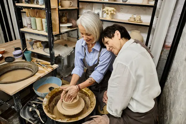 Two women work on pottery in an art studio. — Stock Photo