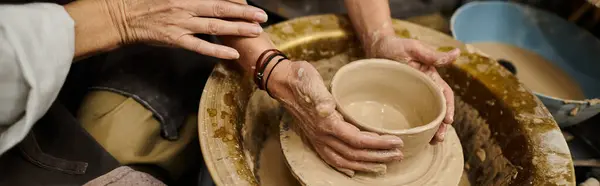 A mature lesbian couple works together on pottery at an art studio. — Stock Photo