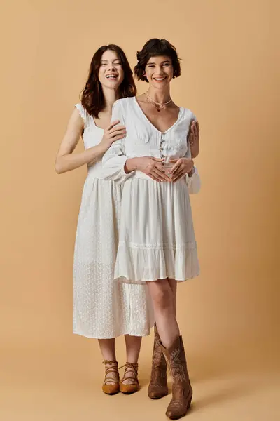 Two young women in white summer dresses stand together in a studio setting. Lesbian couple — Stock Photo