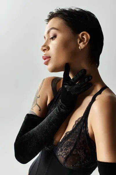A woman in black lingerie poses with long gloves. — Stock Photo