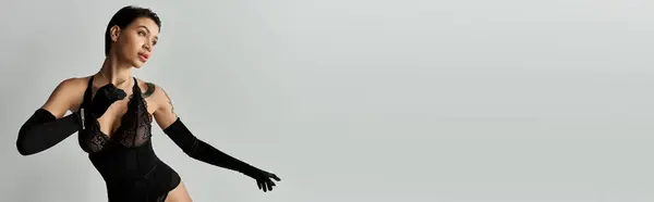 A young woman in black lingerie poses against a white background. — Stock Photo