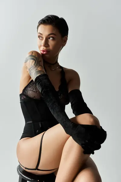 A woman in black lingerie poses with confidence, her gaze looking beyond the camera. — Stock Photo