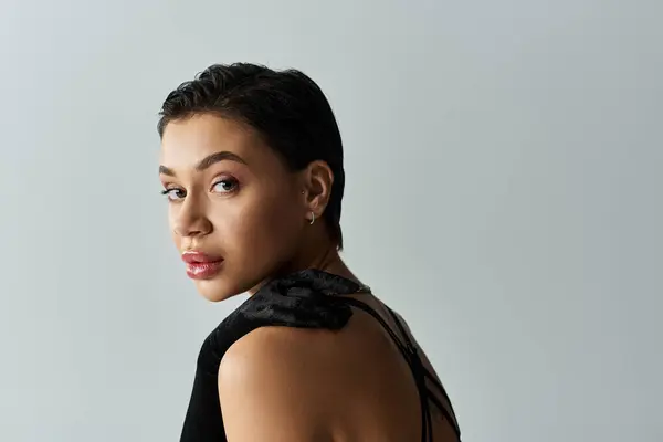 Young woman in lingerie gazes compellingly over shoulder, short dark hair. — Stock Photo
