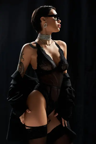 A woman in lingerie poses in a shadowy room. — Stock Photo