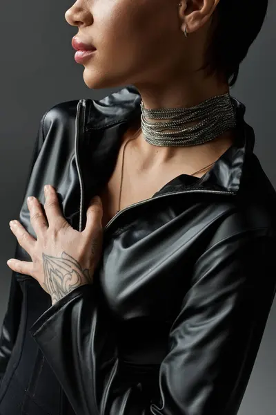 A young woman in black leather jumpsuit poses seductively. — Stock Photo