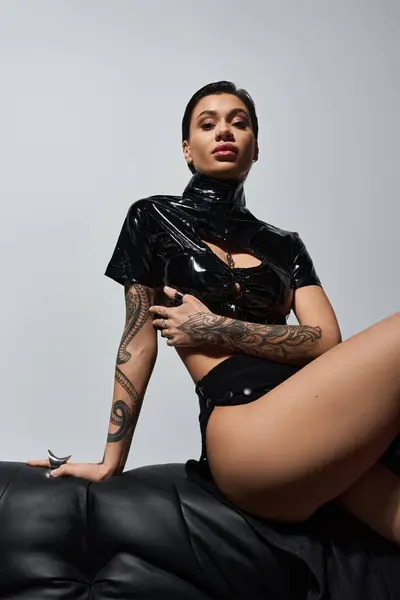Una joven vestida de negro sexy posa seductora. - foto de stock