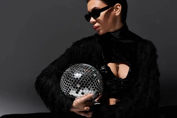 Femme en tenue sexy noire tenant une boule disco. — Photo de stock
