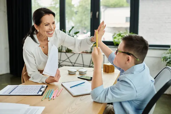 Une mère et son fils cinq ans au bureau ensemble, faisant preuve d'inclusivité et de diversité. — Photo de stock