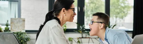 A mother and her son with Down syndrome share a lighthearted moment in an office setting. — Stock Photo