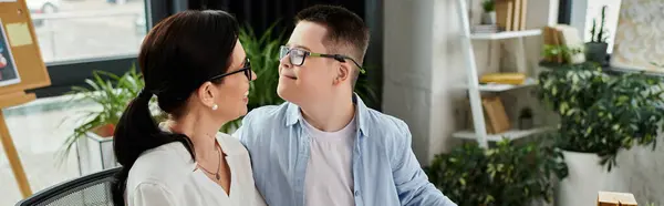 A mother working in her office shares a tender moment with her son, who has Down syndrome. — Stock Photo