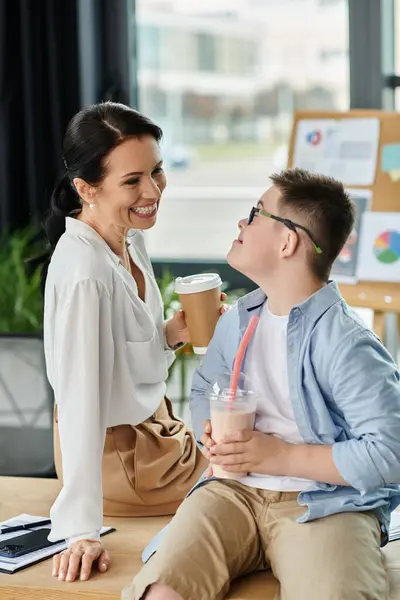 Мать и ее сын с синдромом Дауна разделяют улыбку и выпивку в офисе. — Stock Photo