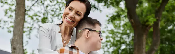 Uma mãe e seu filho com síndrome de Down compartilham um abraço caloroso, mostrando inclusividade e diversidade. — Fotografia de Stock