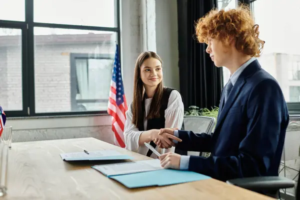Adolescentes en el Modelo ONU, estrechando la mano y discutiendo diplomáticamente. - foto de stock