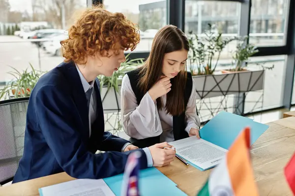 Two teenagers are focused on a document at a Model UN conference. — Stock Photo