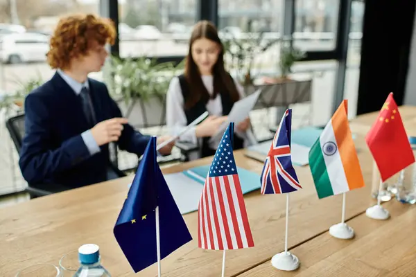 Teenagers participate in a UN Model simulation with flags representing various countries. — Stock Photo