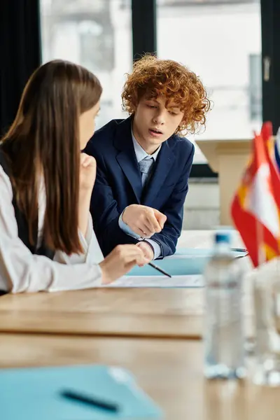 Adolescentes participan en una simulación del Modelo de la ONU, participando en discusiones serias y diplomacia. - foto de stock