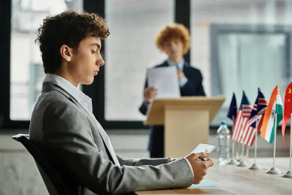 Un adolescent participant à une conférence modèle de l'ONU étudie attentivement les notes. — Photo de stock