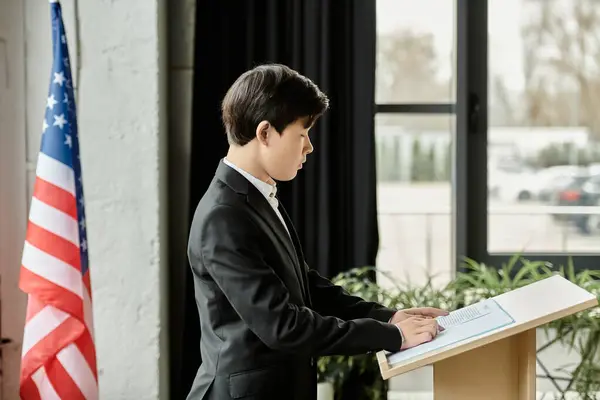 Adolescente se levanta en un podio, preparándose para dar un discurso en una conferencia modelo de la ONU. - foto de stock