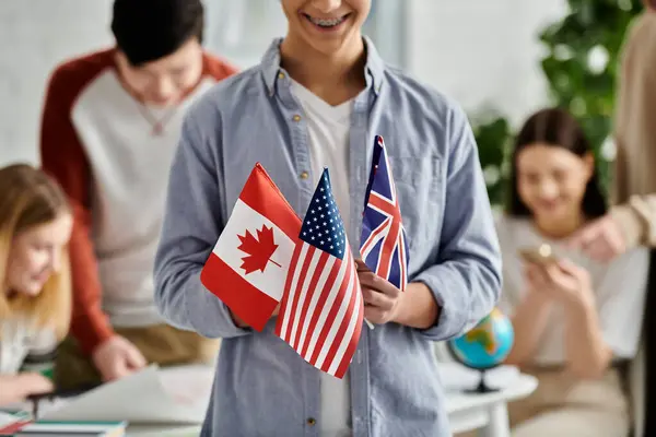 Adolescente segura bandeiras para o Canadá, EUA, Reino Unido no modelo da ONU. — Fotografia de Stock