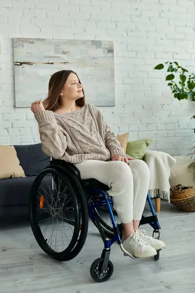 Eine junge Frau sitzt im Rollstuhl in einem gemütlichen Wohnzimmer und genießt einen Moment der Ruhe. — Stockfoto