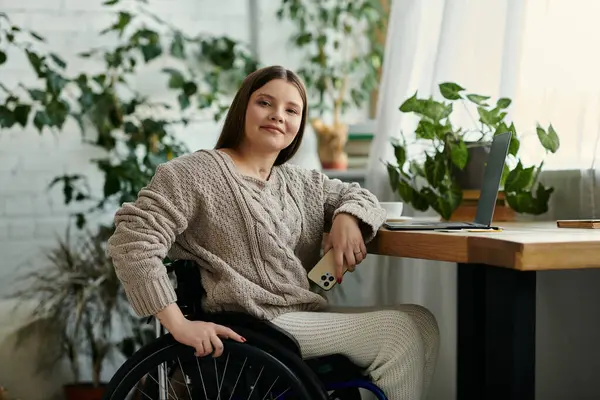 A young woman in a wheelchair sits at home, looking relaxed and at ease. — Stock Photo