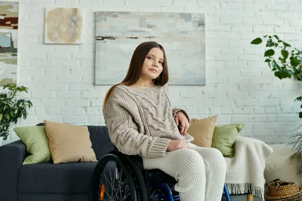 Eine junge Frau im Rollstuhl sitzt in ihrem Wohnzimmer und blickt in die Kamera. — Stockfoto