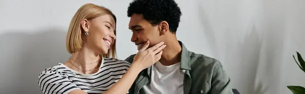 A young multicultural couple enjoys a moment of intimacy and affection in their modern apartment. — Stock Photo