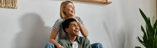 A young, multicultural couple enjoys a playful moment in their modern apartment. — Stock Photo