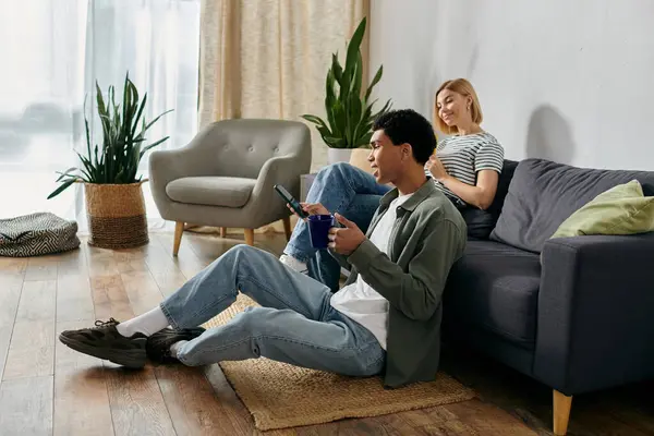 A young multicultural couple relaxes in a modern apartment, enjoying a cozy afternoon together. — Stock Photo