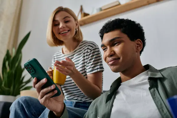 A young couple relaxes in their modern apartment, enjoying a moment of shared technology. — Stock Photo