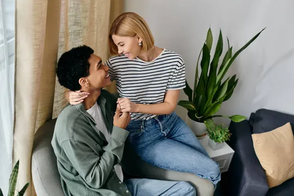 A young multicultural couple enjoys a cozy moment together in their modern apartment. — Stock Photo