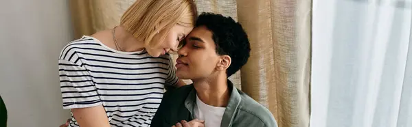 Una joven pareja multicultural comparte un momento íntimo en su apartamento moderno. - foto de stock