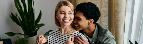A young multicultural couple enjoys a lighthearted moment in their modern apartment. — Stock Photo
